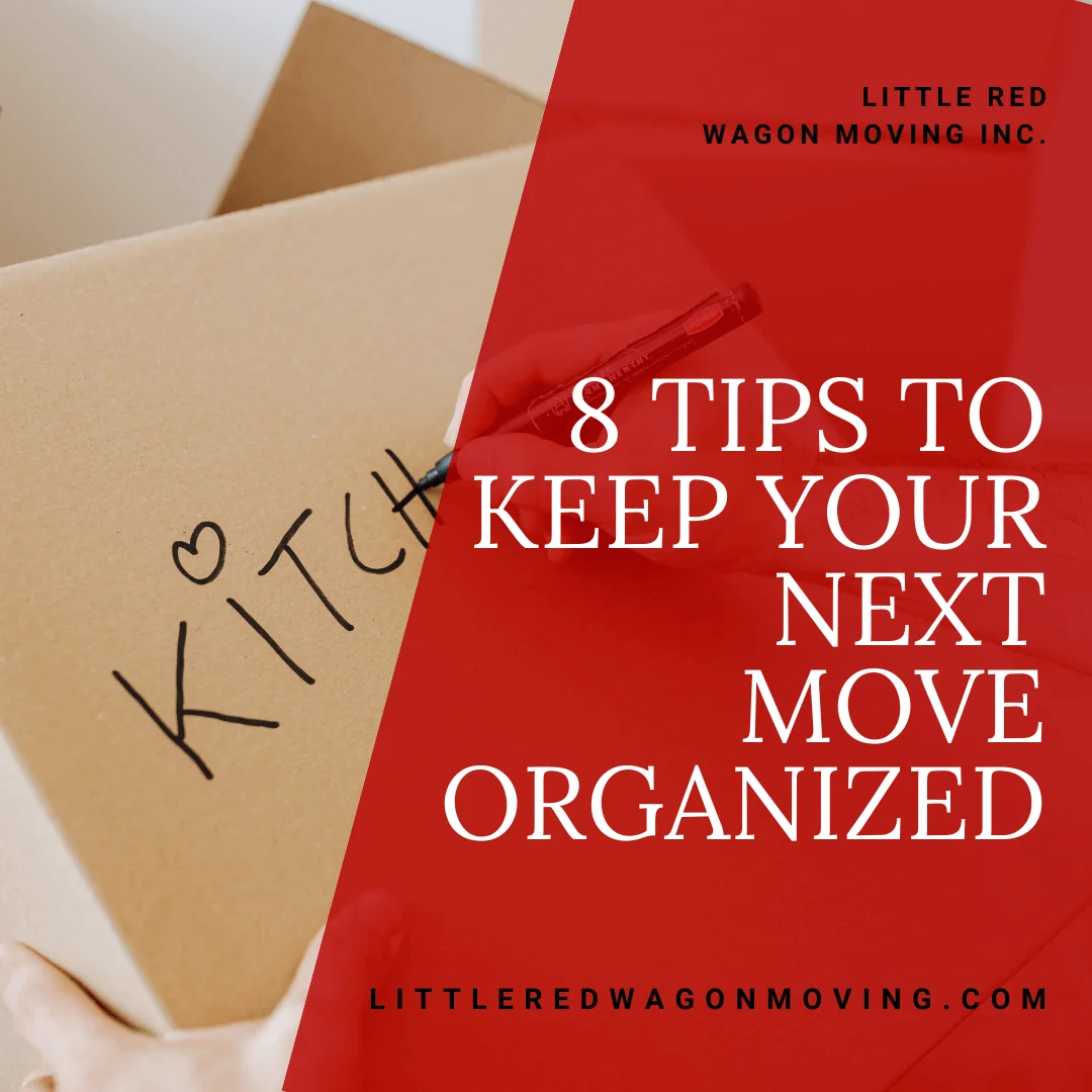 a black marker writes the word kitchen on a moving box